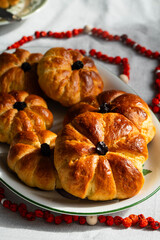 Pumpkin shaped yeast buns with marzipan filling served on vintage plates with natural Autumn decorations on the table.