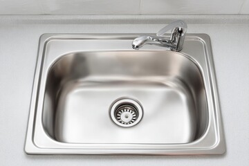 Polished and shiny kitchen sink, drain and faucet