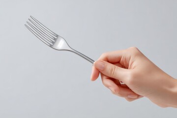 Close-up of a clean, polished fork held by a woman's hand