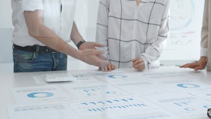 Group of business people is collaborating in modern office environment, analyzing financial data and charts, evaluating performance and developing company growth strategy