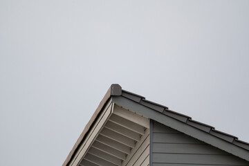 A roof with a gray shingled top and a white trim