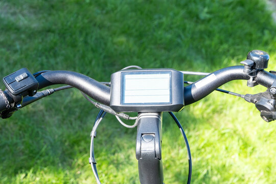 Close-up of electric bike computer on handlebar, detail of modern bicycle technology and digital display