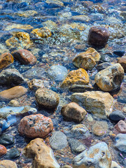 Fototapeta premium The Colorful Rocks Situated in Shallow Water Create a Beautiful and Tranquil Scene
