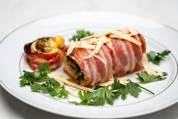 Grilled Chicken Roll Stuffed with Vegetables and Bacon Served on Plate with Fresh Parsley
