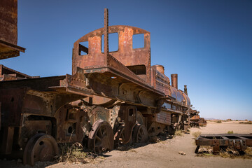 An abandoned locomotive cemetery in Uyuni. Old, rusty, forgotten trains in Bolivia. Sunny day. Blue sky.