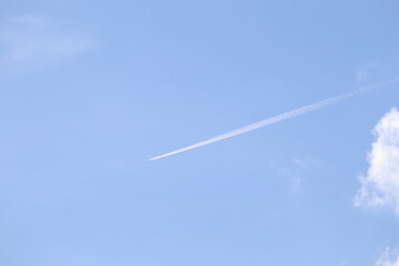 Skybound Trail: Capturing the serene vastness of the clear sky with a solitary contrail marking the path of progress and human exploration.