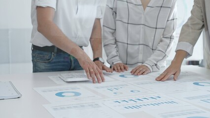 Group of business people is collaborating in modern office environment, analyzing financial data and charts, evaluating performance and developing company growth strategy