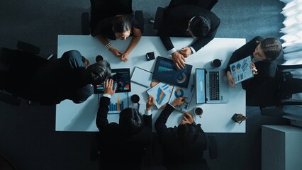 Top down aerial view of smart project manager present growth graph while marketing team analyze chart at meeting table with.laptop, tablet and stock market financial statistic document. Directorate.
