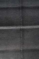 High-resolution scan of folded black paper with visible creases and grid lines. Perfect grunge poster overlay texture for vintage effects, distressed backgrounds, or creative graphic design.