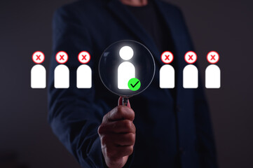 A person holding a magnifying glass focuses on an individual among a group, symbolizing selection...