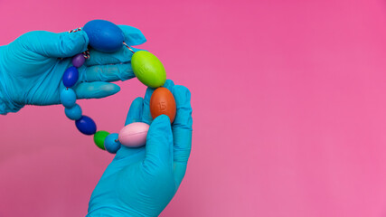 Blue Gloved Hands Holding red Heart and orchidometer On green Background, pediatric urologist's tool