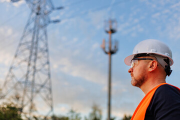 Engineer electric man and electric support of electro transmission lines against blue sky. Control 5g tower.