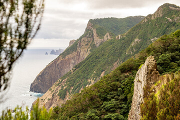 Obraz premium Lush green mountains and cliffs overlooking the ocean.