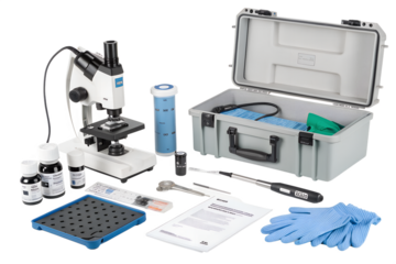 A laboratory microscope with various tools and supplies arranged on a black background. Includes gloves, chemicals, and a storage case.