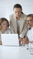 Obraz premium Business team collaborating on a project, analyzing data on a laptop during a productive office meeting, demonstrating teamwork and problem solving skills