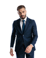 sexy mature businessman in navy blue suit looking forward and walking