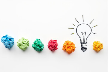 Colorful paper balls with drawn light bulb symbolizing creative idea concept and innovation on white background. Ai generative