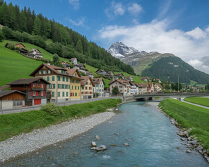 Swiss village with river and snow-capped mountains