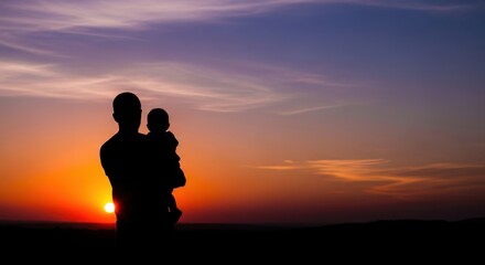 Father holding baby watching a breathtaking sunset over the horizon