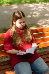 Obraz premium Girl reading a book on a park bench
