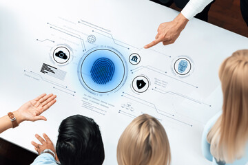 A group of diverse professionals collaborates over a digital interface showcasing security and biometric elements. The setting embodies innovation and teamwork. Trope