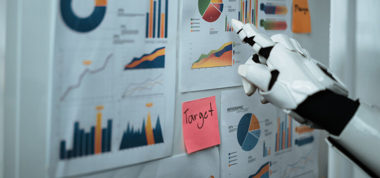 A robotic hand interacts with a collection of colorful graphs and charts pinned to a wall, illustrating advanced data visualization and analysis in a modern office environment.Noogenesis