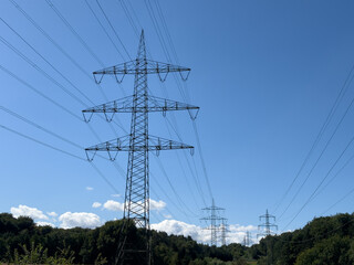Wireless power transmission systems with high-voltage power lines stretching across a clear blue sky, showcasing modern energy infrastructure concepts