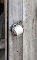 White mug is hanging from a wooden door handle
