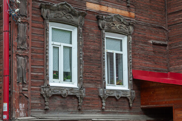 Fototapeta premium in an old wooden house there are two old windows with carved frames
