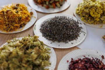 Assorted dried flowers and herbs on paper plates for aromatherapy, tea, natural craft and art therapy