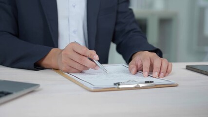 Professional businessman wearing crisp suit sitting at office desk, carefully reviewing contract on clipboard before confidently signing document with pen - Powered by Adobe