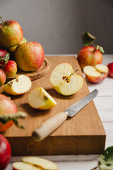 Autumn food. Red apples, whole and sliced on a wooden cutting board, lifestyle