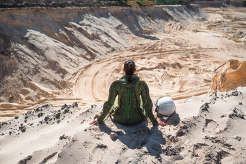 Female astronaut resting with helmet in sand © karrastock