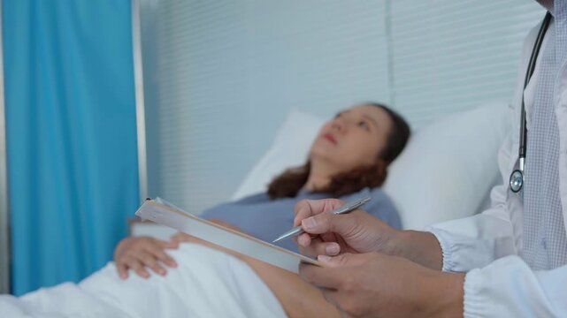 Attentive medical professional documenting patient health details during prenatal hospital consultation, providing comprehensive care for expecting mother