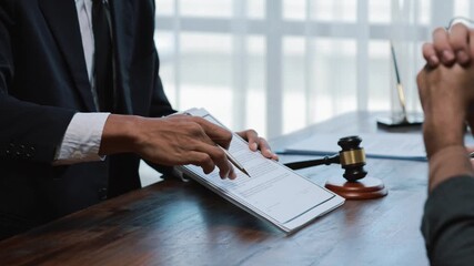Professional lawyer carefully reviewing contract details with client, explaining legal terms and conditions inside modern law firm workspace, preparing for agreement signing - Powered by Adobe