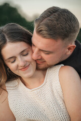 Fototapeta premium Romantic couple embracing in a cornfield, standing forehead to forehead with eyes closed, expressing love, tenderness, and connection in a natural outdoor setting. 