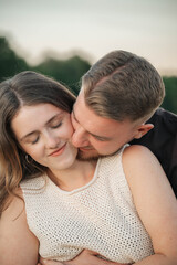 Fototapeta premium Romantic couple embracing in a cornfield, standing forehead to forehead with eyes closed, expressing love, tenderness, and connection in a natural outdoor setting. 