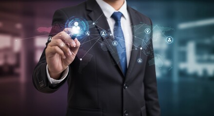 Businessman in suit points at glowing network interface in a blurred office.