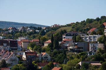 Hillside residential area with houses and greenery
