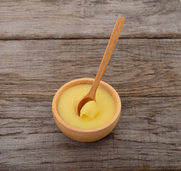 Wooden bowl of ghee clarified butter with spoon