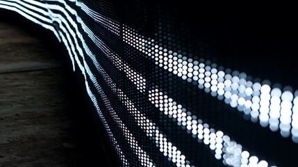 Close-up of illuminated LED light patterns on a dark surface, forming curved lines of bright dots.