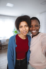 Obraz premium Two young women taking a selfie at home smiling and hugging