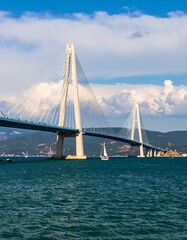 Obraz premium Modern cable-stayed bridge over a body of water on a partly cloudy day
