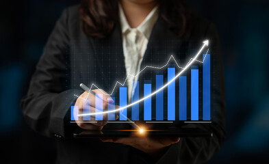 A business professional uses a digital tablet to analyze and present financial growth trends with a rising graph in a modern office setting. Impute