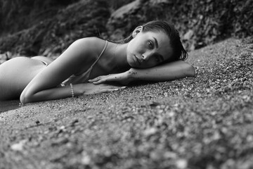 Girl lying on the sandy beach. summer sea. Black and white portrait
