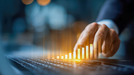 Businessman analyzing digital bar chart projections with illuminated growth data displayed above laptop keyboard in a modern office setting
