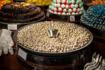 Silver dragee candies with scoop on display
