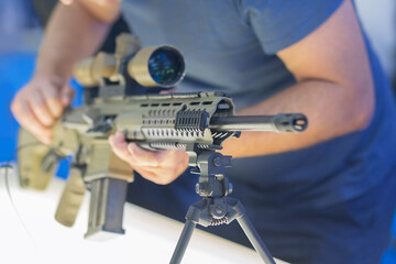 A man examines an assault rifle in an arms store