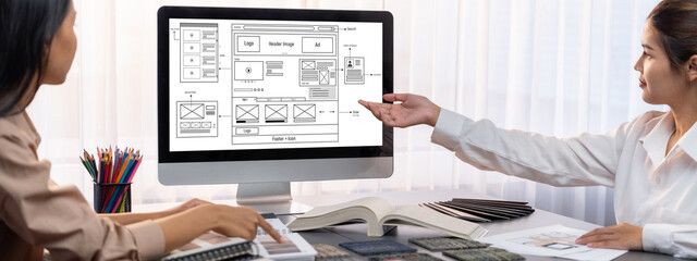 Group of interior architect designer team at table choosing various mood board samples with architecture software on laptop screen. Modern renovation and interior material selection concept. Insight