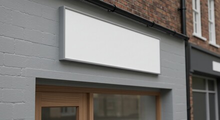 Clean exterior blank storefront sign on a gray brick building wall, perfect for adding your custom business logo.
